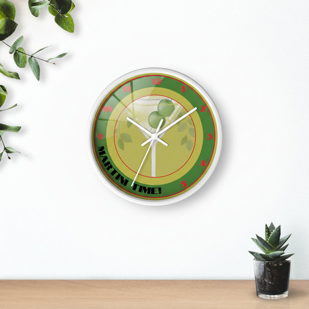 Wall clock with green and red design on a white wall with a plant in the background