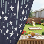Navy curtain with white star pattern in front of a backyard setting with coconuts on a table.