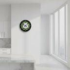 Round clock with black face, green accent, and white patterned center on a white background